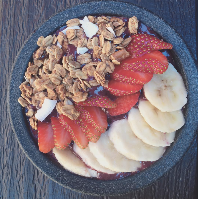 Acai Bowl with sliced bananas and strawberries with granola